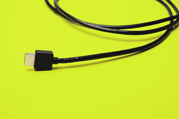 Black HDMI cable on bright green background, minimal technology concept for digital connection, data transfer, media and modern design