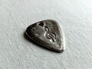 Guitar mediator with treble clef lying in perspective