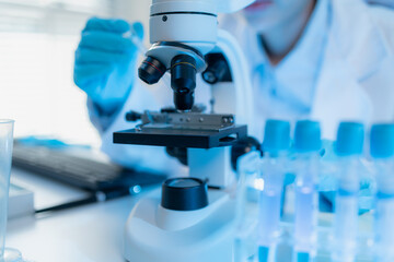 A chemistry researcher in a laboratory surrounded by scientific equipment and test tubes, representing innovation, scientific development, and modern medical research environment.
