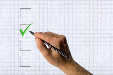 Hand with pencil voting. Hand marking vote box with checkmark.