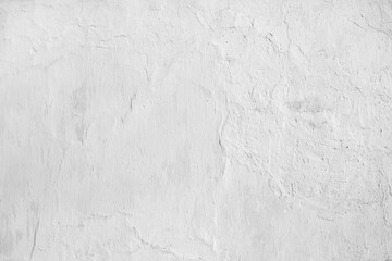 Obraz premium Texture of a freshly painted old white plaster wall with cracks, uneven bumps, and soft shadows as minimalist background