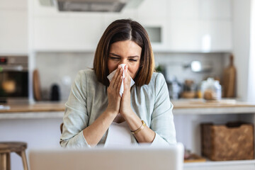 Remote work from home, sneeze and woman with a laptop, sick and illness with fatigue. Female person, freelancer or entrepreneur blowing her nose, virus and flu with online consultation with allergies.