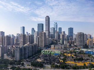 Aerial view of a modern cityscape where skyscrapers pierce the sky above traditional architecture, a contrast of old and new under a vast blue expanse, Chongqing, Chongqing, China.
