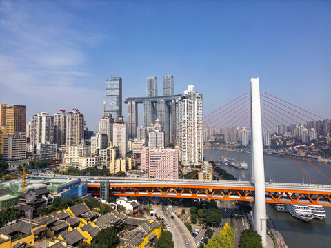 Aerial view of a skyline punctuated by the iconic Raffles City Chongqing complex and the dynamic orange bridge contrasting with the tranquil river, Chongqing, Chongqing, China.