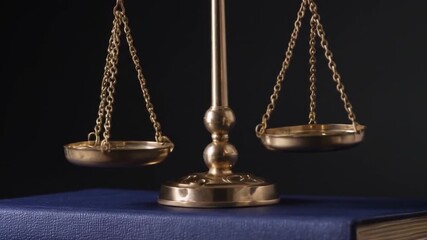 Golden scales of justice on bound book representing law and ethics