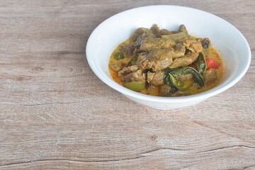 spicy boiled slice beef with lemon leaf in coconut milk green curry soup on bowl