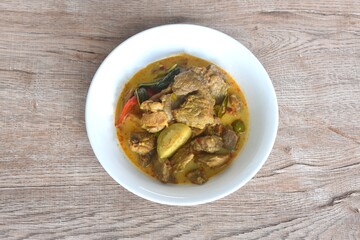 spicy boiled slice beef with lemon leaf in coconut milk green curry soup on bowl