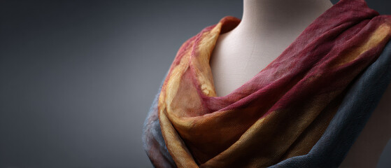 Warm drape scarf woven textile ethnic pattern layered fabric soft texture muted color boho style elegant wrap artisan craft neck accessory gently embraces mannequin with cozy charm and subtle