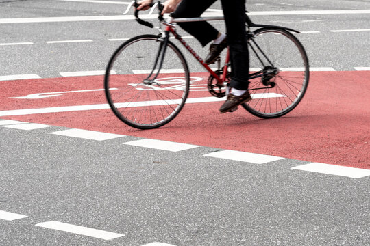 Cyclist riding bicycle across urban crossing showing cycling movement mobility and transportation infrastructure in active street scene
