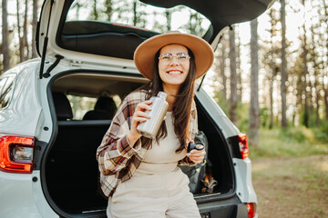Naklejka premium Woman enjoying travel freedom in forest with reusable bottle