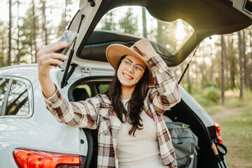 Woman taking selfie enjoying freedom on a road trip