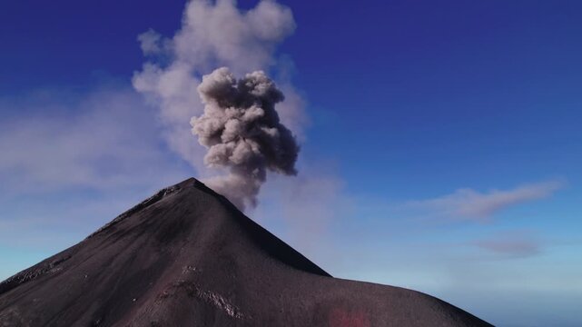 Acatenango, Guatemala - A Burst of Ash Erupts from the Steep Volcanic Peak, Drifting Upward Against the Bright, Open Sky - Close Up Shot