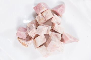 Light purple taro cubes with speckled patterns, starchy root prepared for cooking.