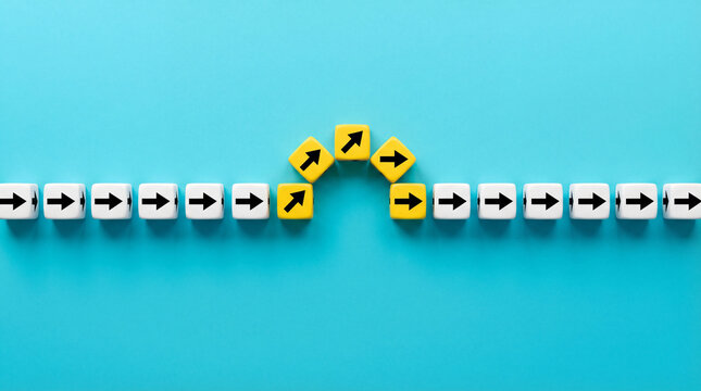 Business strategy concept showing change of direction and alternative path with arrow blocks on blue background.