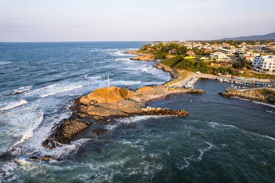 Aerial view of where the sapphire sea crashes against the rugged coastline near a small harbor, Lozenets Southern Cross, Lozenets, Tsarevo, Bulgaria.