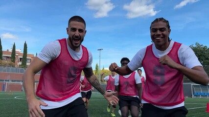 Happy soccer players running together during training session - Powered by Adobe