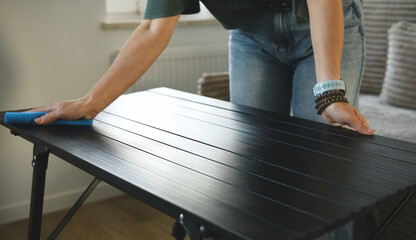 Girl Polishing The Table Surface With A Cloth As Part Of The Room Cleaning Routine