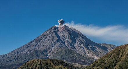 Majestic Volcano Erupting Under Clear Blue Sky.