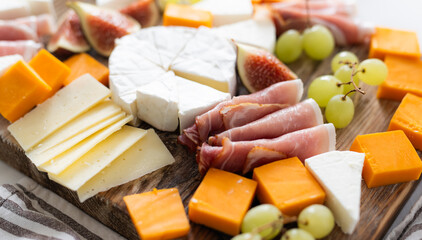 Cheese Board With Fruits And Ham On A Table As An Appetizer For A Party