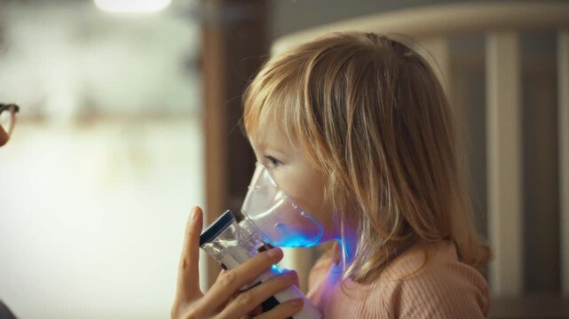 Caring mom administers medication treatment to her child using a nebulizer device, carefully securing the mask to their face for effective inhalation therapy, prioritizing their health and well-being
