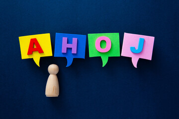 Wooden figure communicating greeting ahoj in speech bubbles