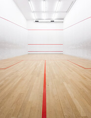 Indoor squash court with wooden floor and white walls. Symmetrical composition - wide-angle...