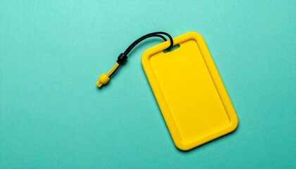 Yellow luggage tag on turquoise background, travel accessory.