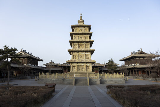 View of a towering pagoda, intricately carved with ancient motifs, stands as a testament to time amidst traditional buildings, Datong, Shanxi, China.