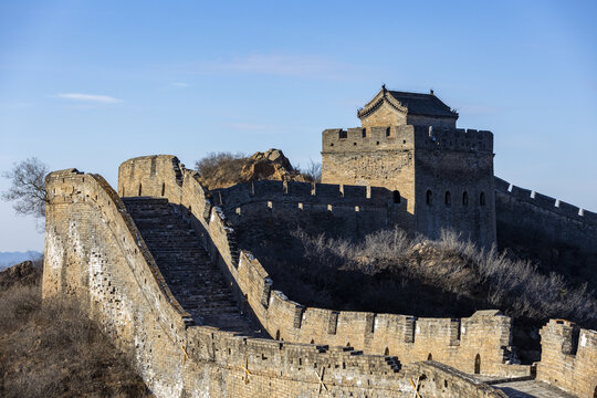 View of ancient stone walls snake across the rugged terrain under a clear sky, showcasing the grandeur of history and architectural marvel, Chengde, Beijing, China.