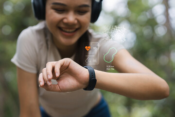 The concept of health and fitness using smartwatch technology: An Asian woman smiles while using a smartwatch with a heart rate display and GPS map. There is also space for additional text.