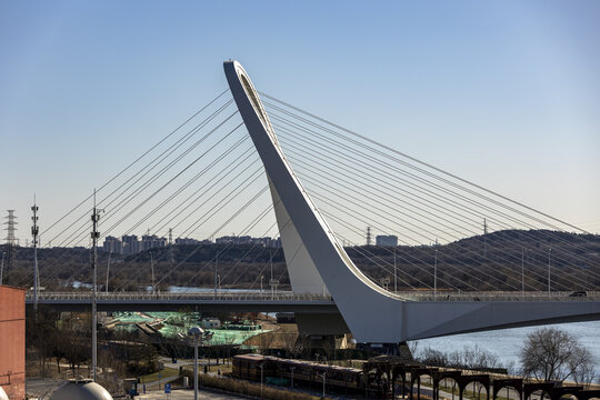 View of the striking white bridge with its elegant, soaring arch and intricate web of cables against the clear blue sky, Beijing, Beijing, China.