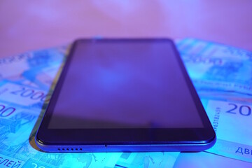 A tablet and paper bills on the table. Finance and economics.