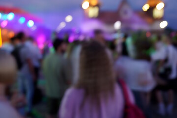 Blurred background. A city festival with people. Evening concert. A festive event. Crowd.