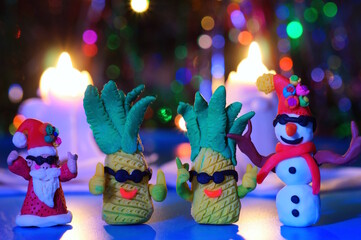 Fairy-tale characters: Santa, pineapple and snowman with glasses on the background of burning Christmas candles. New Year's mood.