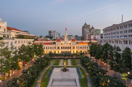 Aerial view of the illuminated Ho Chi Minh City Hall and statue amidst the green trees and manicured lawns, Ho Chi Minh City, Ho Chi Minh City, Vietnam.