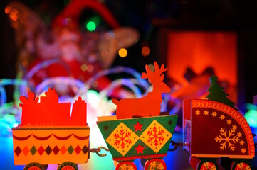 Wooden Christmas train on the background of Christmas tree toys.