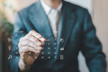 Businessman marking with target icon 1 January 2026 calendar virtual screen. Concept of time management, schedule planning, appointment reminder, business agenda, deadline, and organizing work plan.