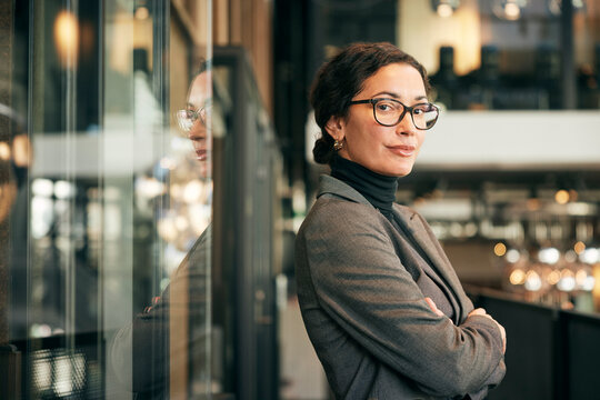 Portrait of confident mature female entrepreneur standing with arms crossed in law firm