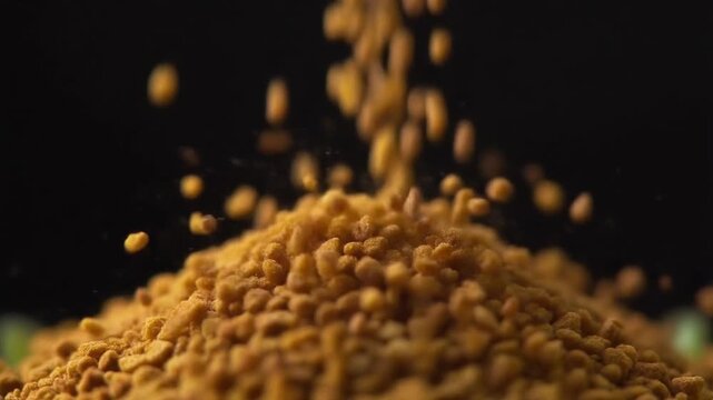 Golden granular particles gracefully falling onto a growing pile in an ultra-macro shot, showcasing