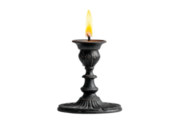 A single candle alight in an ornate, dark metal candlestick, isolated on a stark black background