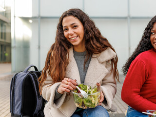 Female university students enjoying a salad during their lunch break