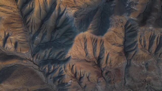 Aerial view of the rugged terrain of Calanchi del Cannizzola, showing contrasting shades of brown and grey, creating a textured landscape, Centuripe, Sicilia, Italy.