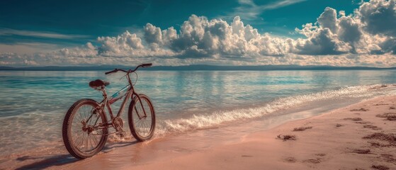 Fototapeta premium Bicycle on beach shore with ocean view and cloudy sky travel concept