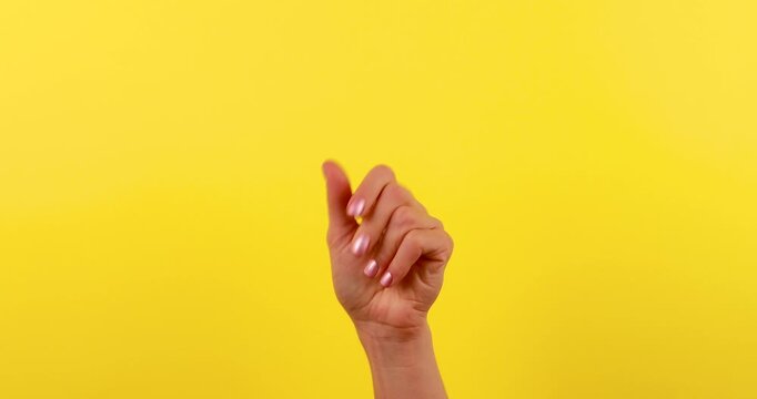 4K stock footage of a hand snapping fingers against a bright yellow background. The clean, minimalist composition highlights the gesture, making it ideal for social media, advertising, presentations, 