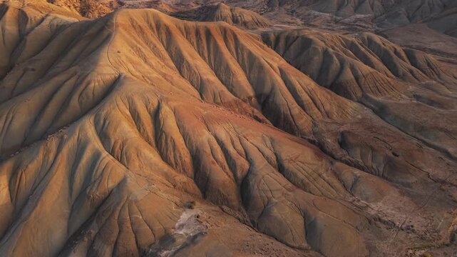 Aerial view of the arid landscape of Calanchi del Cannizzola, with its ridges and valleys painted in shades of brown and tan, Centuripe, Sicilia, Italy.