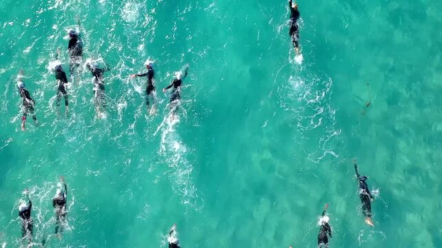 Aerial photo of a swimmers in open water swimming competition in turquoise sea