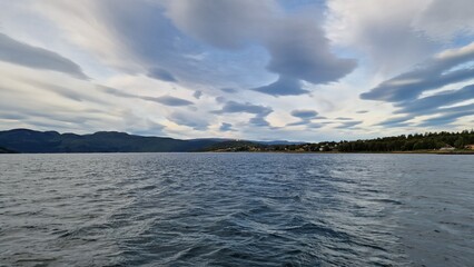 A fjord in Fauske, Norway, framed by rugged mountains and calm waters, is particularly striking in autumn. The surrounding slopes are painted in shades of gold, red, and orange as the deciduous trees 