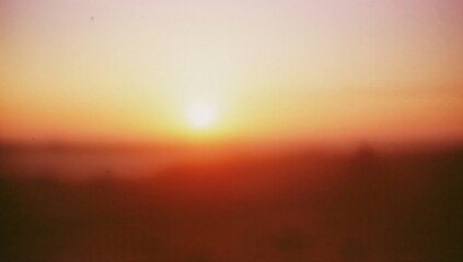Blurred sunrise or sunset background with vibrant colors and gradient effect creating atmospheric mood