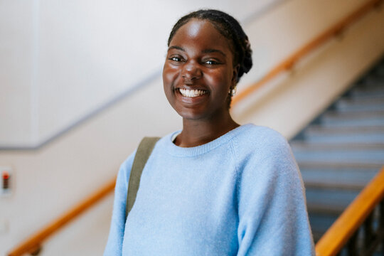 Portrait of female adult student with toothy smile in university campus