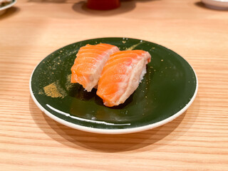 日本の寿司。回転寿司のお皿に乗ったサーモン握り寿司。